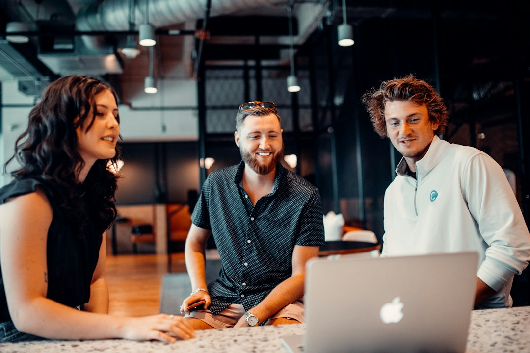 Marketing professionals collaborating around a laptop